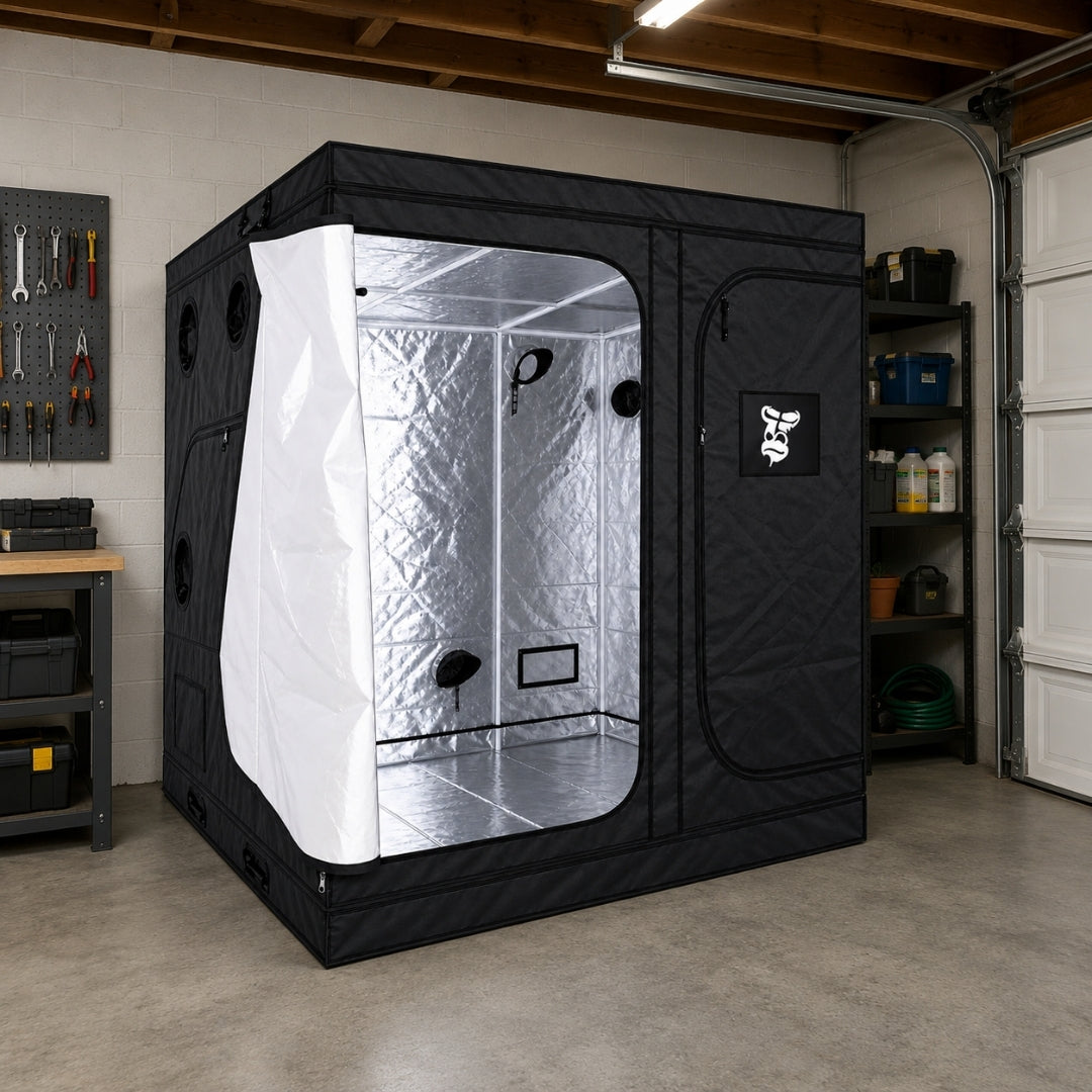 A black GorillaBox Deluxe grow tent with a reflective silver interior, shown set up in a garage workshop environment.