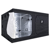 A black GorillaBox Deluxe grow tent measuring 4m-3m-2m with a reflective silver interior, shown with the front door partially open. The tent features a zippered side pocket with a small gorilla logo patch and ventilation holes on the side.