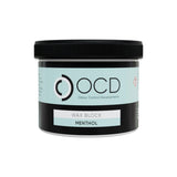 A jar of OCD Odour Control Developments Wax Block in the Menthol scent, featuring a black lid and a label with a light blue and black design.