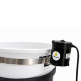 A close-up of a white plastic bucket with a silver metal band, and a black cylindrical motor attached on the side.