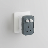 A Mission Controls LOGIC-FAN fan controller plug-in, featuring a dark gray front faceplate with a white UK three-pin wall outlet and a white rotary speed control knob, set against a plain white background.