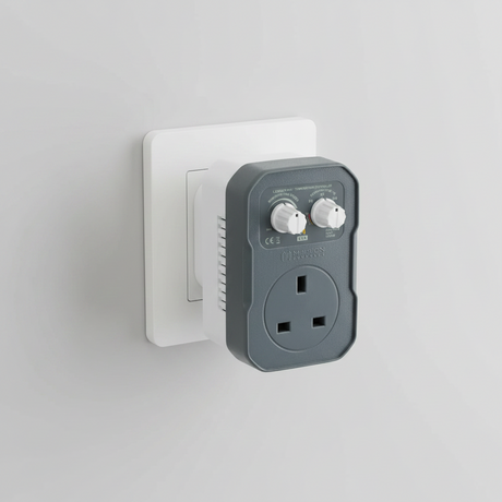 A Mission Controls LOGIC-FAN fan controller plug-in, featuring a dark gray front faceplate with a white UK three-pin wall outlet and a white rotary speed control knob, set against a plain white background.