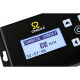 Close-up of a black Omega electronic controller with a blue backlit LCD screen showing 'SUNRISE SUNSET' and time settings, on a white background.